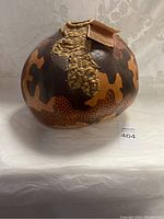 Front view of rounded fiber art sculpture showing patchwork pattern and woven top detail