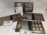 Full view of multiple commemorative nickel coin sets in display cases with certificates of authenticity