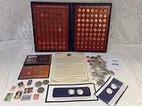 Full view of two framed collections of Lincoln Wheat pennies, multiple sets of coins with certificates, assorted loose coins, and commemorative coin booklets.