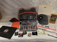 Photo showing the full collection including jersey, tote bag, cap, pins, patches, season pass, souvenirs, and booklets.