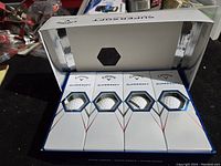 Open box showing four individual boxes, each presumably holding three golf balls, totaling one dozen.