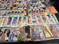 Photo showing a large selection of basketball rookie cards arranged in rows with visible logos and player images