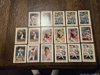 Overview of 17 1986 Topps baseball cards featuring Hall of Famers and superstars, arranged on wooden surface