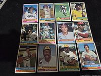 Photo showing 12 1976 Topps baseball cards laid out on black surface, featuring Hall of Fame players.
