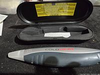 Photo of Cold Heat cordless soldering tool in black molded carrying case with warning labels inside lid.