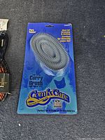 Close-up of one Comfy Care Curry Brush with blue packaging showing details and use