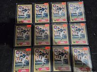 12 Greg Maddux rookie baseball cards displayed front in protective sleeves, showing consistent image and condition.