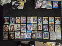Top-down view displaying 30 Roger Clemens baseball cards laid out in rows on black surface with various card designs visible.