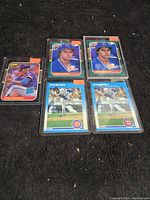 All five Greg Maddux rookie cards arranged face up showing card fronts and protective top loader sleeves.