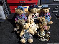 Photo of nine assorted Boyds Bears in various outfits, posed on a black cloth background
