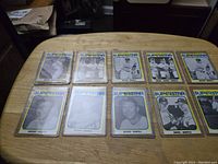 10 Mickey Mantle baseball cards laid out flat on a table, showing front images with blue Superstar titles and yellow border