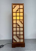 Front view of the illuminated Japanese-style screen lamp with rosewood frame and decorative carved details.