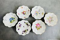 Top-down view of all six Shelley fine bone china saucers showing two different floral patterns.