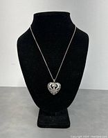 Full view of sterling silver heart pendant necklace displayed on a black jewelry bust to show design and length.