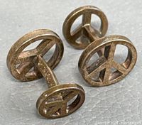 Side angle showing the peace sign design and general condition of the cufflinks.