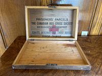 Open handmade wooden box showing interior lid stencil text from Canadian Red Cross Prisoners' Parcels crate.