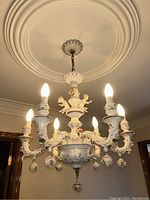 Front view of six-light porcelain chandelier hanging from ceiling medallion