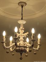 Front view of six-light porcelain chandelier lit and suspended from ceiling