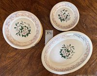 Set of dogwood floral plates with 22kt gold decorative border and trim, including lunch and bread and butter plates plus an oval serving plate.