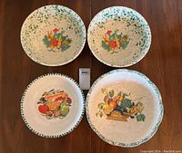 Top-down photo showing all four bowls with their colorful painted designs and green rim accents.