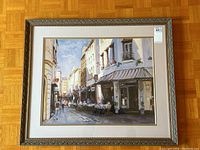 Front view of the framed street scene print with visible ornate silver frame and matted border.
