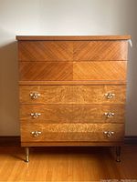 Front view of vintage highboy dresser with four smaller top drawers and three larger bottom drawers, showing some missing drawer hardware.