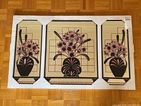 Full set of three mirrors still in original packaging showing black vases with pink flowers on beige backgrounds arranged side by side