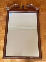 Full view of vintage wall mirror showing walnut wood frame and mirror glass with etched lines.