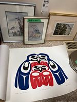 Three framed prints leaning against a wall including two Sue Coleman nature prints and one additional framed print; price tag visible on one print