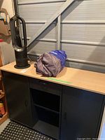 Overall view of cabinet top holding fan and car cover