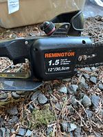 Close-up front-side view of Remington chainsaw showing brand, power rating, and cutting bar length.