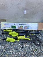 Overview image of Sun Joe multi-tool attachments with packaging showing 3 tool options and components laid on gravel