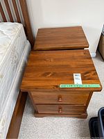 Pair of wood nightstands positioned next to a bed, showing overall size and finish.