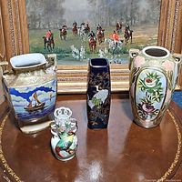 Lot of four antique and vintage hand painted porcelain vases displayed in front of a horse painting.