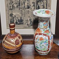 Both vases side by side in front of framed artwork showing overall size, shape, and design details