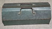 Closed green metal toolbox with handle on top and latch on front
