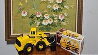 Photo showing both the Tonka Mighty Diesel front loader toy and Little Tikes school bus box.