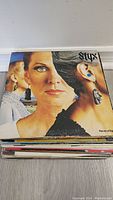 Top record album is Styx - Pieces of Eight with a distinctive cover featuring a woman's face split with another woman in the background.