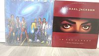 Two vinyl record covers shown side-by-side: one with Jackson 5 group photo, one 'In The Closet' album with close-up eyes of Michael Jackson.