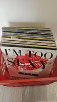 Photo showing a mixed lot of vinyl records, visible album cover with text 'I'm Too Sexy' and graphic of red lips.