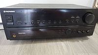 Front view of black Pioneer VSX-454 audio/video stereo receiver showing main control panel with buttons, dials, and volume knob.