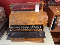 Front view showing embossed cover, keys, glass display and felt shelf