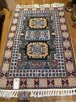 Full view of rectangular Berber rug on wooden floor, fringe visible