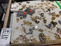 Overview of assorted gold-tone and silver-tone costume jewelry pieces spread on fabric
