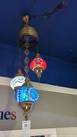 Assembled fixture hanging from ceiling with three mosaic glass globes in red, white, blue