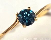 Top-down view showing round blue diamond and prong setting
