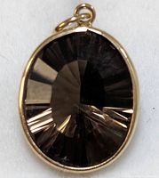 Close-up of oval faceted smokey quartz stone in 10KT gold bezel setting pendant.