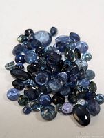 Pile of various natural blue genuine sapphire gemstones, assorted cuts and sizes, total weight 10.8 carats approximately.
