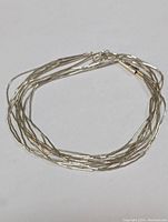 Full view of the silver necklace coiled.