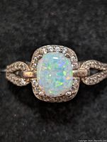 Close-up front view of the sterling silver ring with opal and clear stone halo